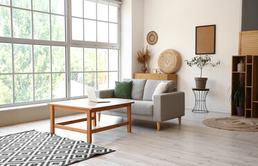 Canvas Print - Interior of light living room with sofa and laptop on table