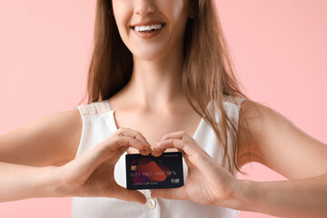 Sticker - Young woman with credit card on pink background, closeup