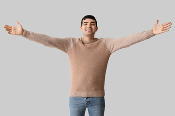 Wall Mural - Happy young man opening arms for hug on light background