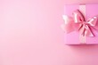 Delicate pink gift box adorned with a silky satin bow on a matching pink background, space for text. Pink Gift Box with Elegant Satin Ribbon