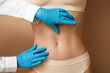 Leinwandbild Motiv Young woman with flat belly and plastic surgeon on beige background, closeup