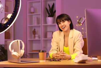 Canvas Print - Young woman recording podcast in studio at night