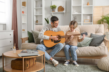 Canvas Print - private music teacher giving guitar lessons to little boy in living room