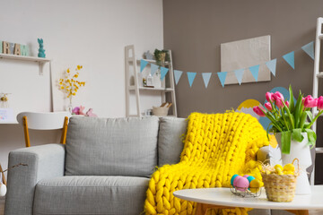 Wall Mural - Comfortable sofa with soft plaid in room decorated for Easter celebration