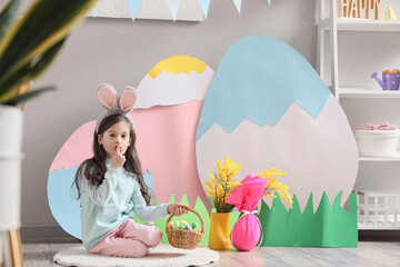 Canvas Print - Cute little girl with Easter basket showing silence gesture in festive room