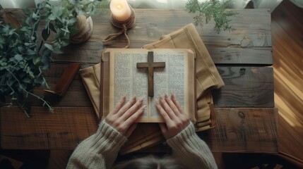 Wall Mural - beautiful young woman reading the bible holding an old wooden cross on a table
