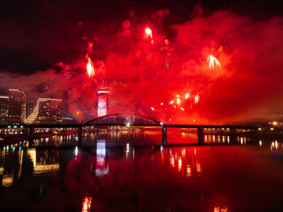 Wall Mural - Drone flight above colorful fireworks on the black sky background over-water