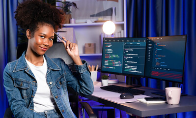 Wall Mural - Young African wearing jeans shirt, IT developer presenting program on computer screens displaying coded data of application and website, creating innovative updated software version. Tastemaker.