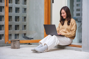 Wall Mural - portrait image of a young woman working on laptop computer at home