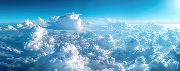Wall Mural - a stunning aerial panorama of dense cumulus clouds bathed in sunlight, with a clear blue sky above.