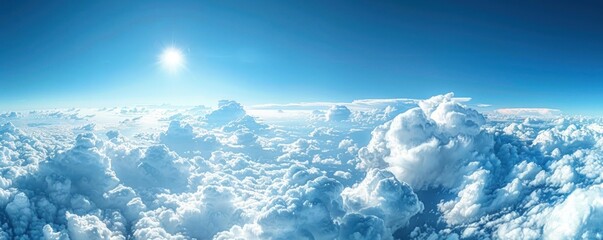 Wall Mural - a stunning aerial panorama of dense cumulus clouds bathed in sunlight, with a clear blue sky above.
