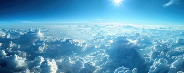 Wall Mural - a stunning aerial panorama of dense cumulus clouds bathed in sunlight, with a clear blue sky above.