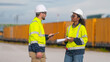 © APchanel - Engineers railway survey wearing safety uniform and helmet under conversation document on hand inspect checking cargo containers railway work on railroad station is transportation industry concept