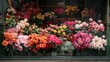 A quaint flower shop window overflows with lush, beautifully arranged bouquets of roses, inviting passersby to admire the natural beauty and fragrance