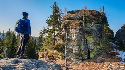 Poster - Hiker man with scenic view of massive rock formation Grossofen in idyllic forest in Modriach, Hebalm, Kor Alps, border Carinthia Styria, Austria. Refreshing hiking trail in remote Austrian Prealps