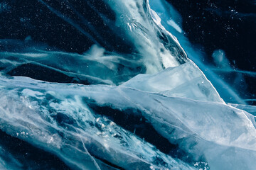 Wall Mural - Transparent blue ice with cracks on Baikal lake in winter. Abstract winter nature background.