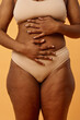 © AnnaStills - Conceptual studio shot of unrecognizable young Black woman in underwear posing for camera with hands on her belly