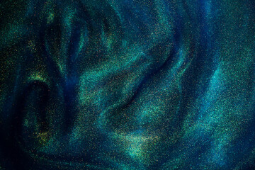 Wall Mural - bursting gold dust particles in blue liquid. abstract gold sparkling particles in blue fluid with gr