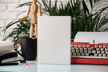 Sticker - Hardcover book and vintage typewriter on white desk