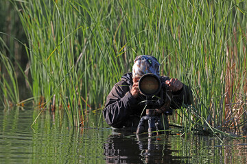 A man taking a photo in the water.