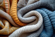 A Close Up Of A Pile Of Knitted Blankets Stacked On Top Of Each Other