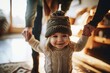 A joyous toddler in a winter hat takes guided steps while holding onto an adult's hands in a warmly lit home setting, Generative AI