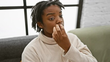 Poster - Secret expression, young black woman with dreadlocks, sitting in cozy home, zipping lips shut with finger