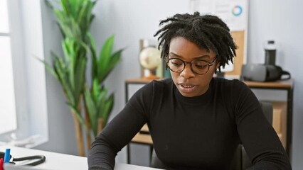 Canvas Print - Focused african american woman with dreadlocks working in a modern office environment.