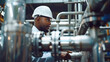 black male engineer worker inspects pipes in a factory