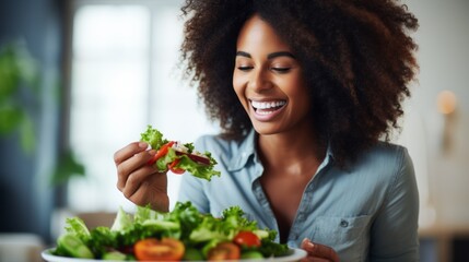 Wall Mural - Close-up of a happy smiling Beautiful black woman with curly hair eating a vegetable salad at home. Breakfast, Lunch, Healthy lifestyle, Healthy food, Balanced Nutrition concepts.