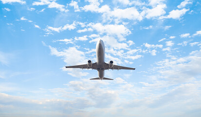 Wall Mural - White passenger airplane flying in the sky amazing clouds in the background - Travel by air transport