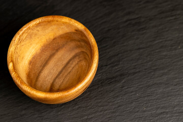 Wall Mural - an empty wooden bowl on a black slate table