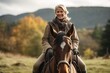 Senior woman riding a horse in the autumn forest. Outdoor portrait.