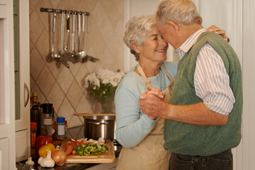 Poster - Senior, couple and smile with dancing in kitchen for bonding, support and holding hands while cooking. Elderly, man and woman with hug, embrace or happiness for relationship, dancer and love in home