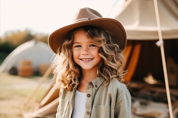 Wall Mural - Outdoor portrait of cute little girl in cowboy hat smiling at camera