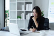 © itchaznong - Businesswoman working on laptop with using a calculator to calculate the numbers reading finance accounting concept