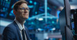 © Gorodenkoff - Portrait of an Adult Working in International Stock Exchange Company: Professional Using Computer with Multiple Screens, Monitoring Financial Markets, Communicating with Corporate Business Partners