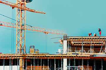 Large construction site including several cranes working on a building complex