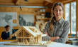 jeune femme architecte à côté d'une maquette de chalet en bois