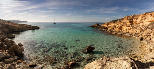 Sticker - panorama view of an idyllic cove at Es Cap Enderrocat in southern Mallorca with a sailboat at anchor