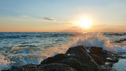 Wall Mural - colorful sunset with large sun under the sea waves.