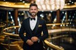 Handsome young man in tuxedo and bow tie is posing in luxury hotel.