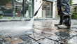 A man washes paving stones in his yard with a pressure washer close-up