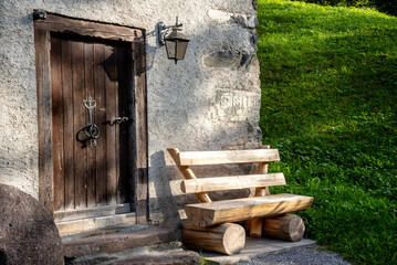 Wall Mural - Facade of an old mill with an wood bench in the canton of Glarus in Switzerland