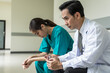 © Jack Tamrong - Chinese doctor sitting with female nurse feeling stress with works in hospital