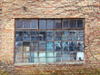 Ein altes Fenster mit Metallrahmen in eine Klinkerfassade