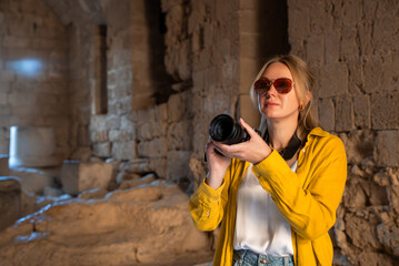 Wall Mural - A woman tourist with a camera inside an ancient temple.