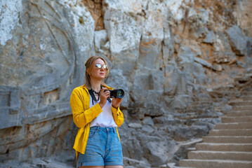 Poster - Woman tourist with a camera on an excursion.