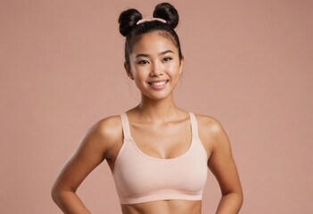 Wall Mural - A fit young woman stands in a sports bra, ready for a workout. Her hair is styled in double buns, adding a playful touch to her active look.