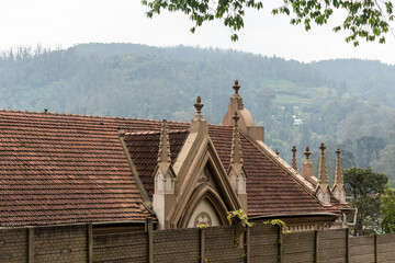 Sticker - The roof and spires of the old Union Church overlooking the Nilgiri hills in the town of Udhagamandalam.